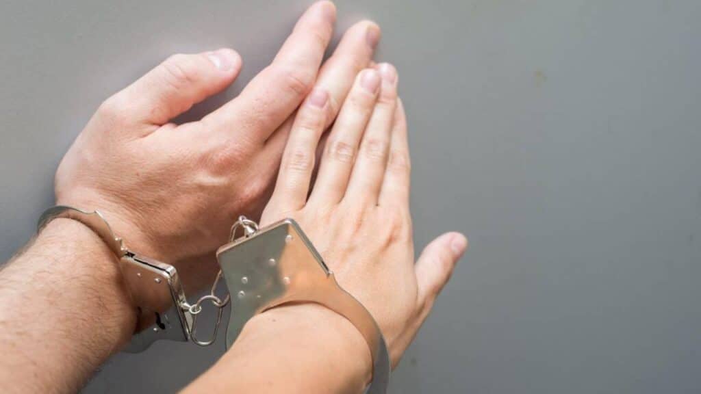 Hand of a man and a woman in metal handcuffs close-up. Codependency concept