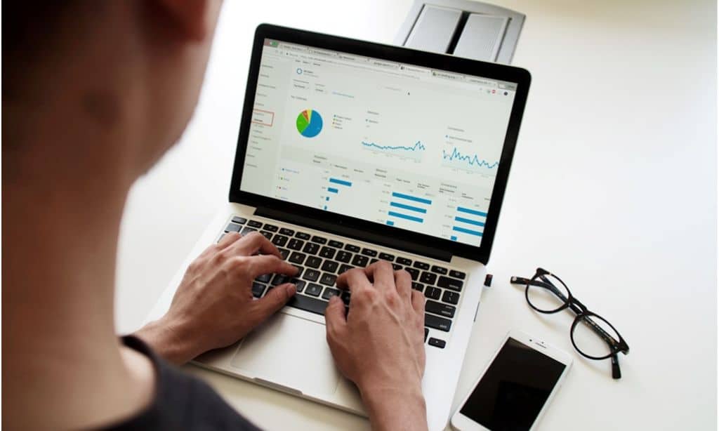 A project manager monitors key financial metrics on a laptop.