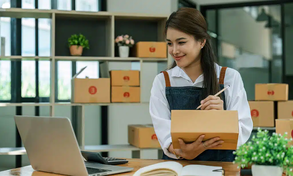 Smiling woman preparing a package for shipping