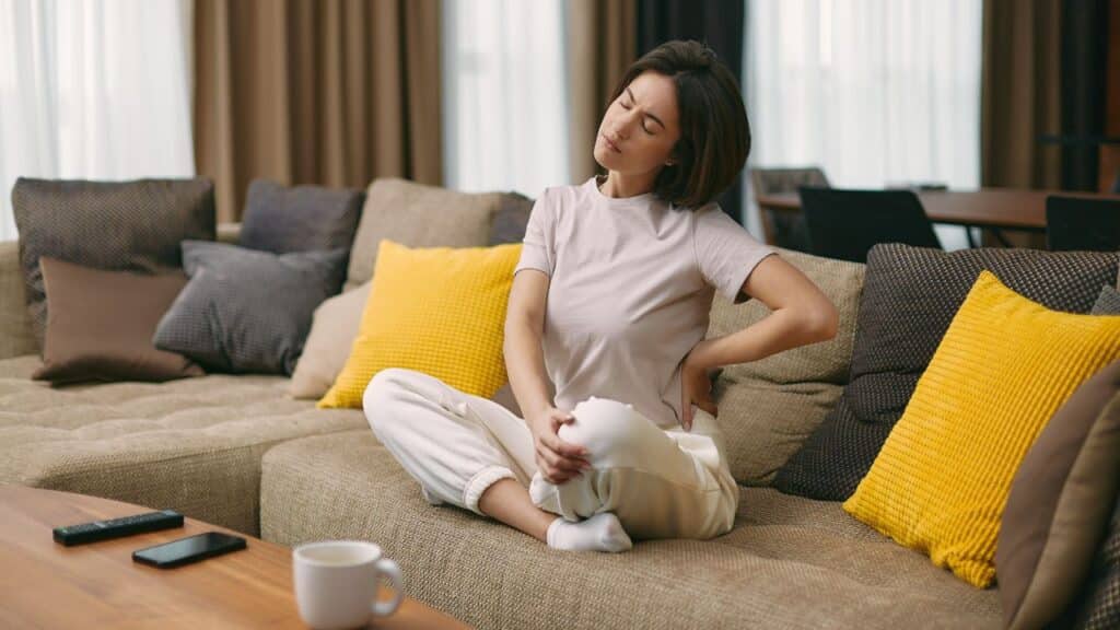 She appears to be experiencing some discomfort as she stretches