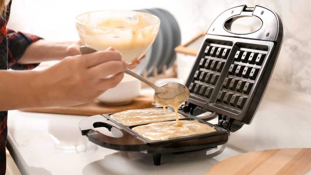 Pouring waffle batter into a hot waffle iron