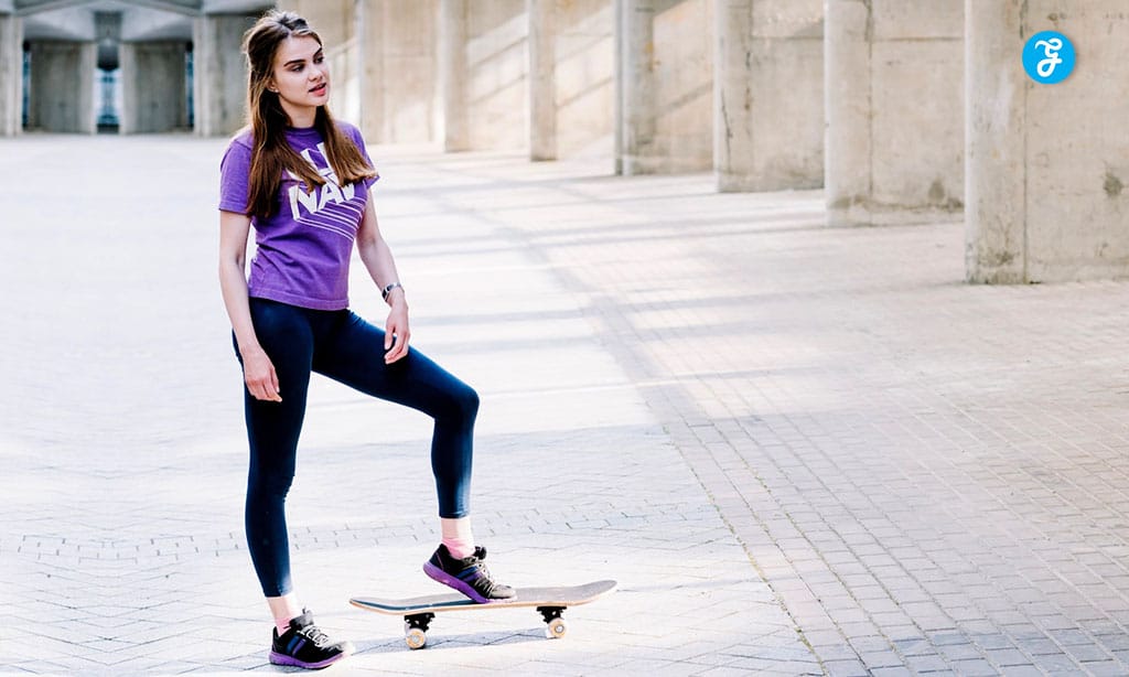 Young woman in casual purple t-shirt and leggings standing confidently